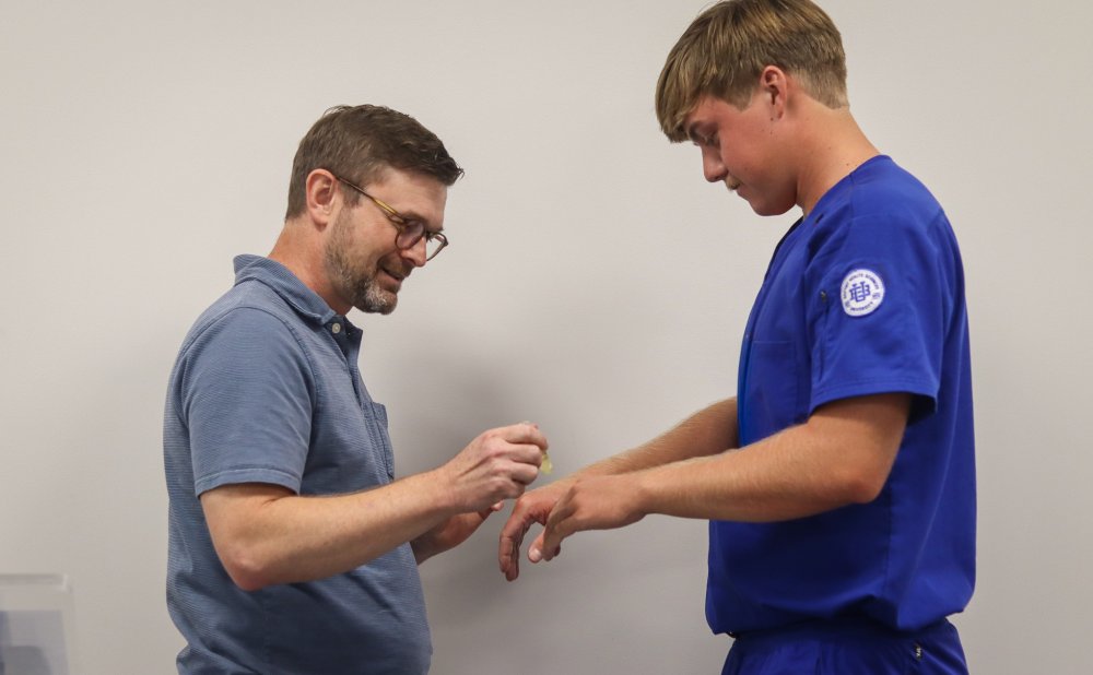 A BHSU faculty member anoints a nursing student’s hands during the Blessing of the Hands ceremony.