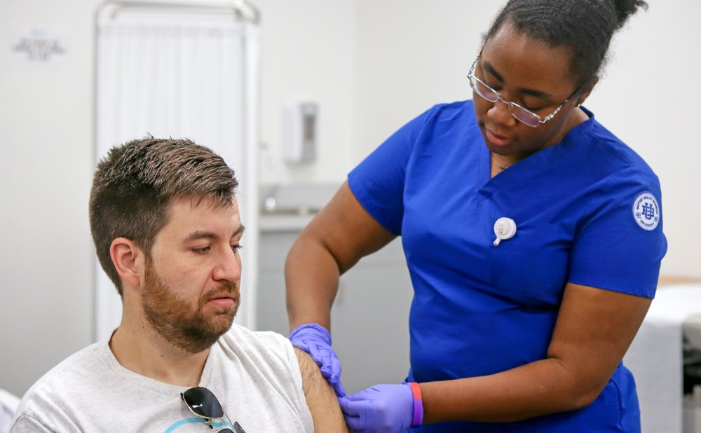 BHSU nursing student administers flu vaccine to faculty member during Employee Flu Clinic.