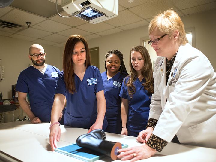 Faculty training students on clinical equipment