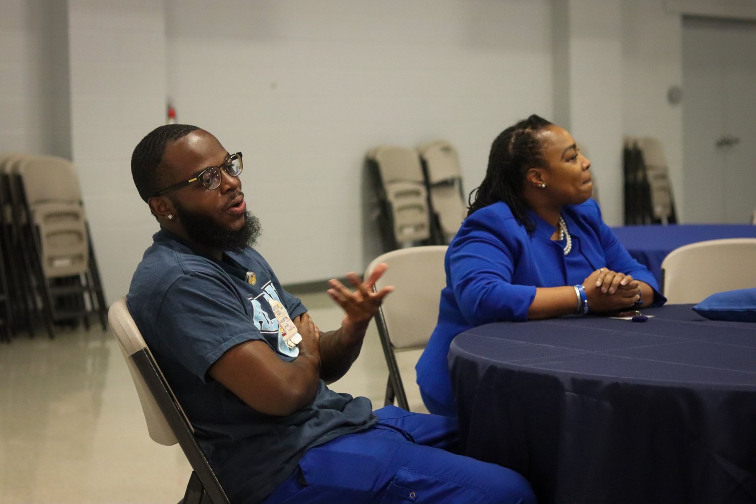 A alumni and faculty member seated at a round table listening attentively during the networking event.