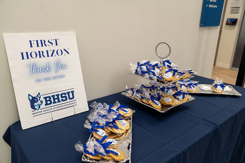 a sign with the event title on it and cookies on a table