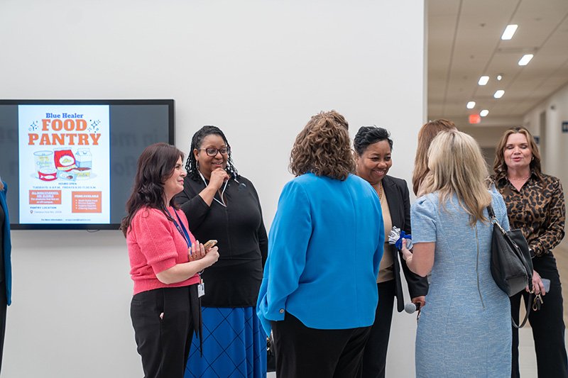 A group of individuals talking and laughing with smiles on there faces