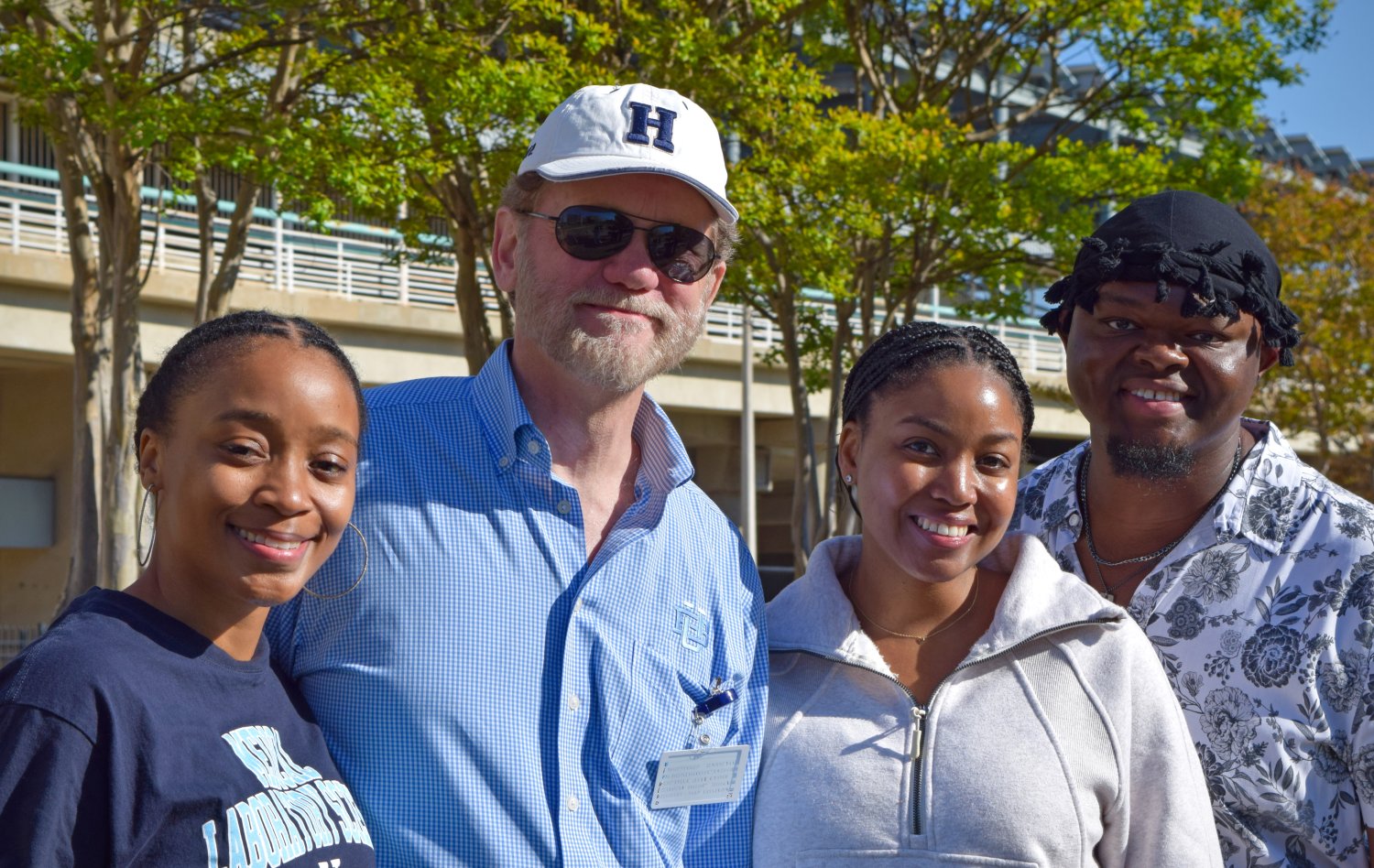 four people smiling at the camera 
