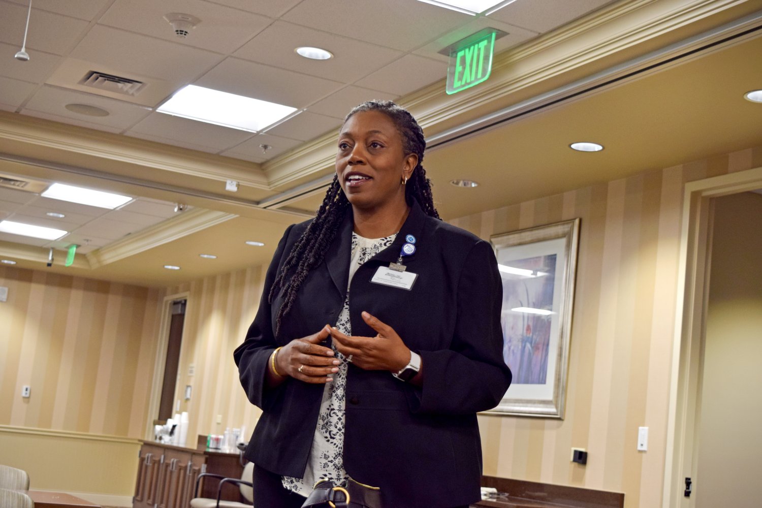 Ann-Salina Tucker, Director of the BUCOM, addresses the audience during the Lunch and Learn session, smiling while speaking in a professional setting.