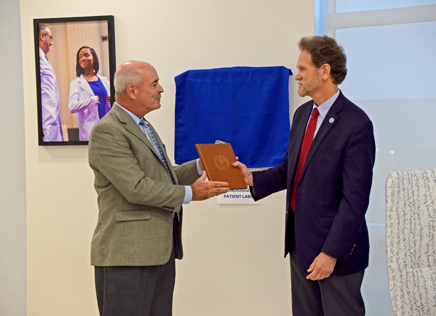 NBOME President gifting Dean with Book 
