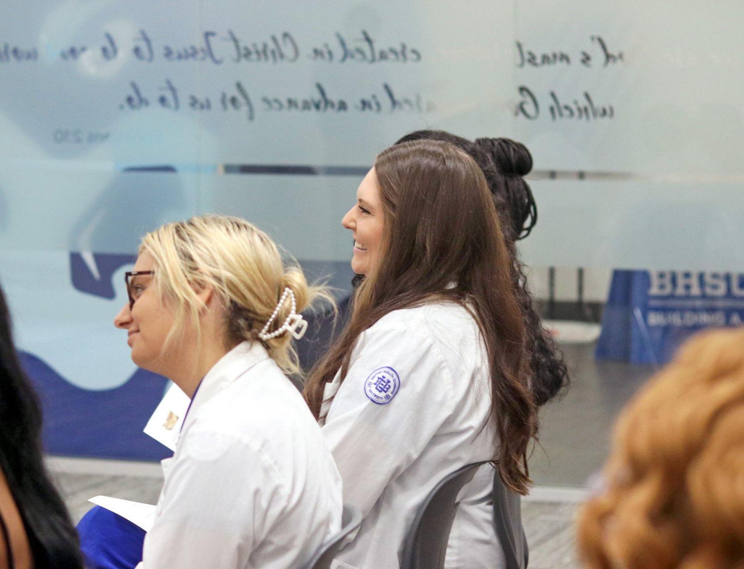 two students looking forward while smiling 