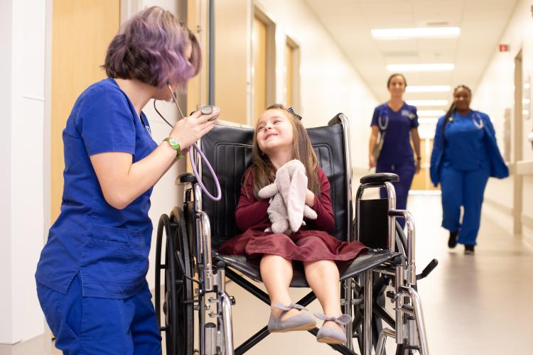 Nurse in hospital cheering up kid patient 